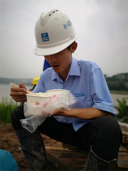 图一：熬夜浇筑完混凝土的张斌席地吃盒饭.jpg